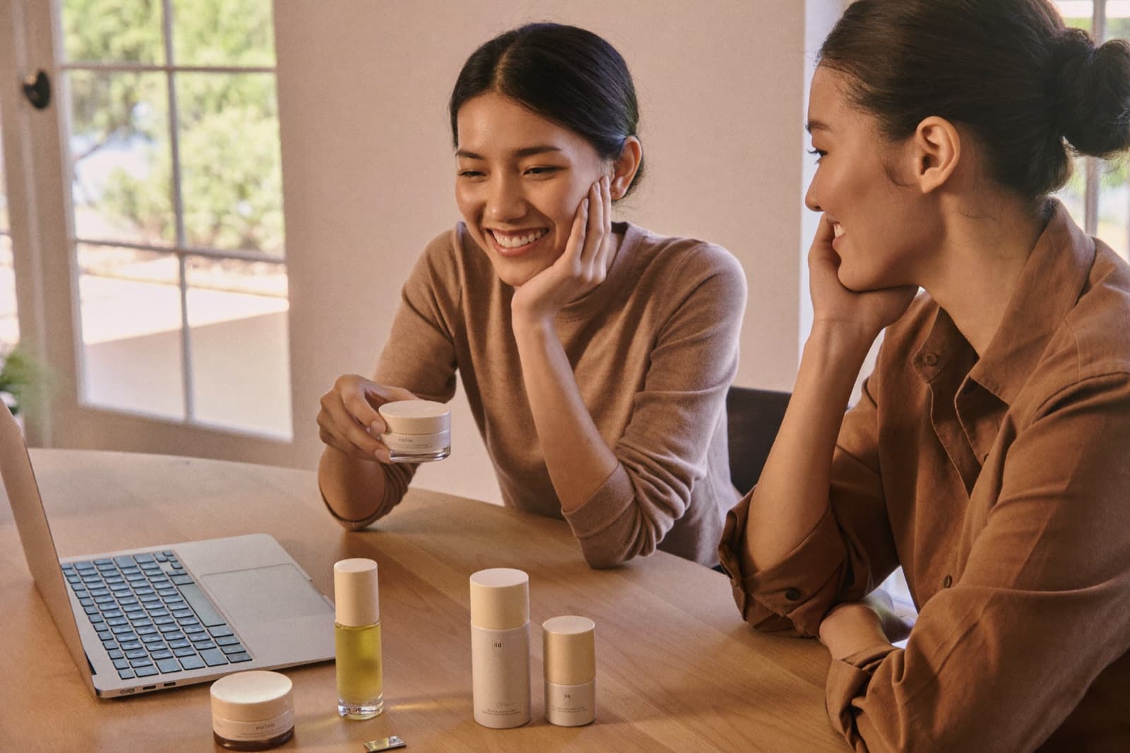 An Indonesian brand founder talking through her products with a partner over a laptop