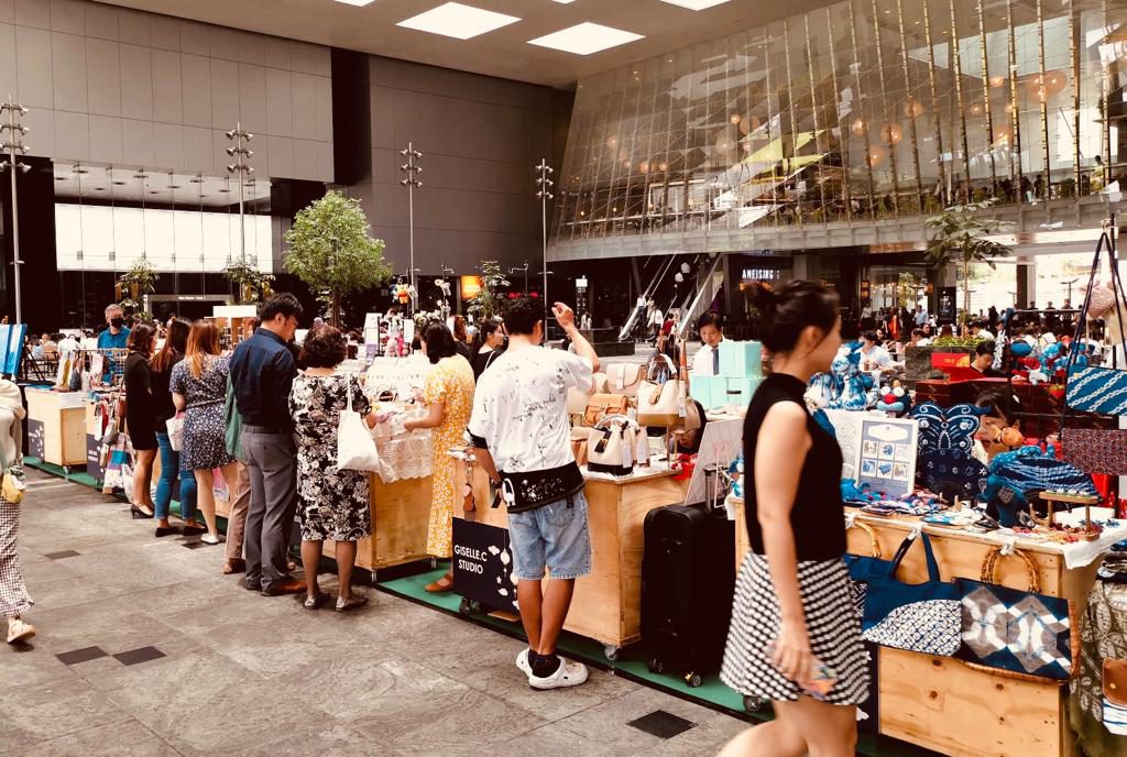 Shoppers gathered around vendor booths at a Crafters' Market at Asia Square, Singapore