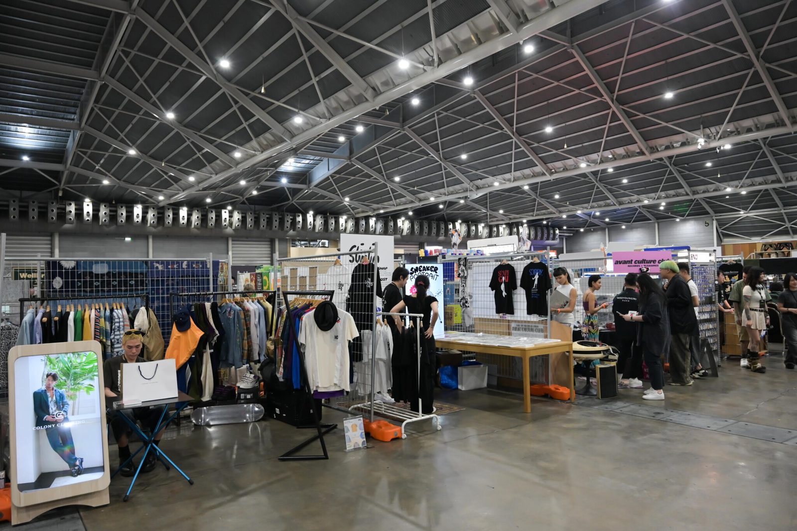 Visitors browse streetwear on rails and grid-wall stalls in the market area of Culture Cartel 2025 at Singapore Expo