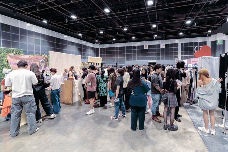 Visitors browse K-pop merchandise and fashion booths inside a Suntec Singapore convention hall at HallyuCon