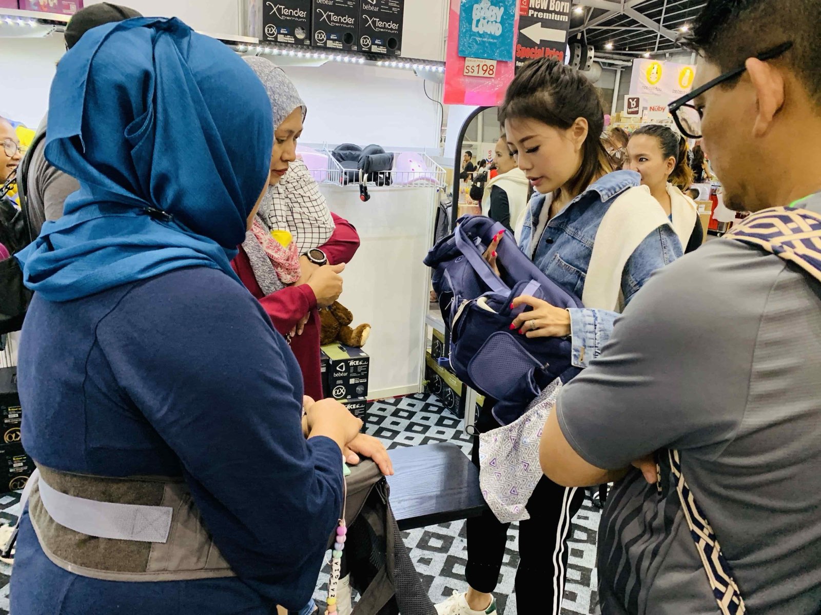 Parents trying on a baby carrier at an exhibitor stand at Mummys Market Baby Fair, Singapore Expo
