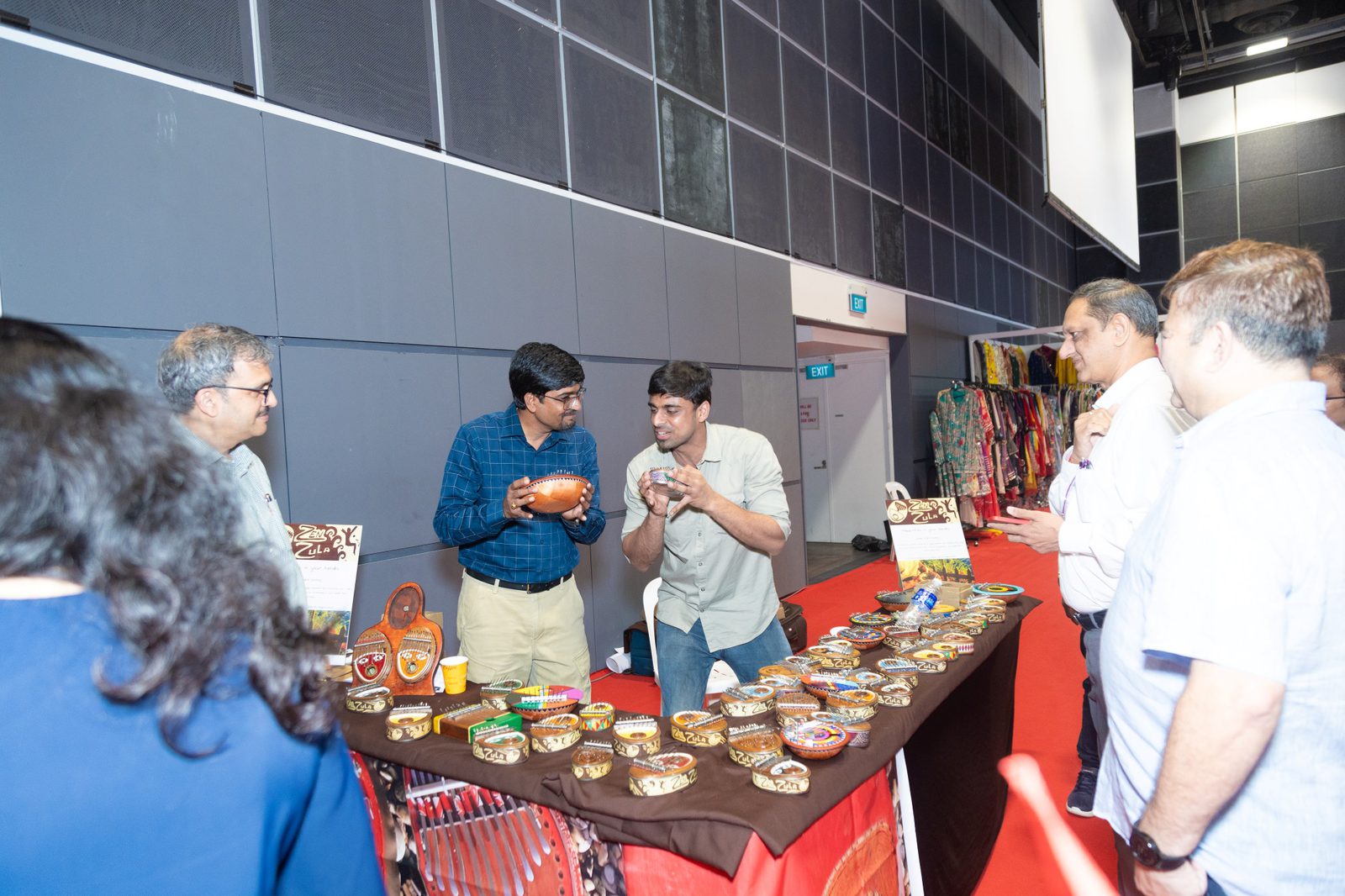 A seller shows a small hand-held thumb piano to visitors at a table of handmade instruments at Namaste Bharat in Suntec Singapore, October 2024