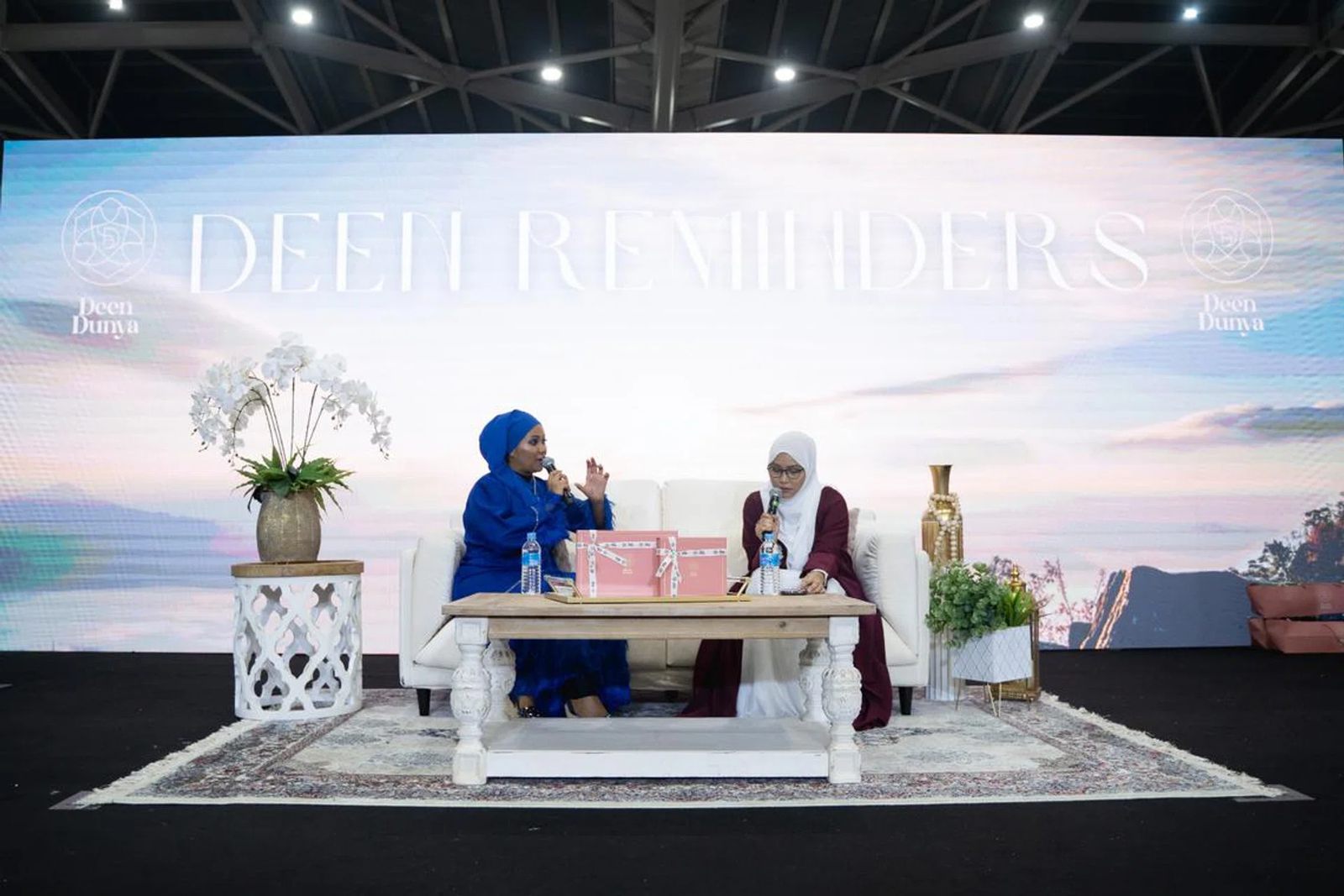 Two women in hijab hold a talk on a sofa set on the Deen Reminders stage at SalamFest, Singapore EXPO