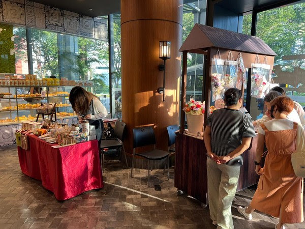 A vendor stall and kiosk with shoppers inside Breadtalk IHQ at Tai Seng, Singapore