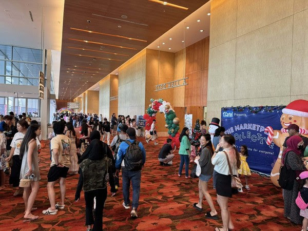 Crowds arrive through the red-carpeted Expo Hall A foyer at Marina Bay Sands, Singapore, past a Christmas balloon arch and a gingerbread-man Marketplace Collective backdrop