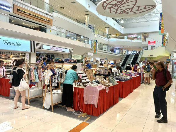 Vendor booths and shoppers filling the east atrium of Thomson Plaza during a T Cartel bazaar, Singapore