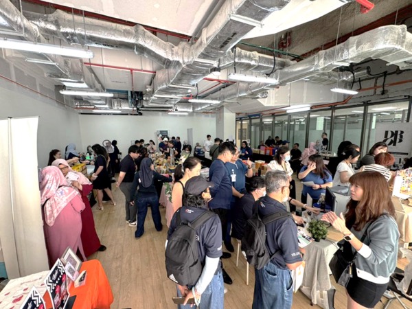 Hospital staff and visitors browsing vendor stalls at a T Cartel bazaar inside Woodlands Health, Singapore